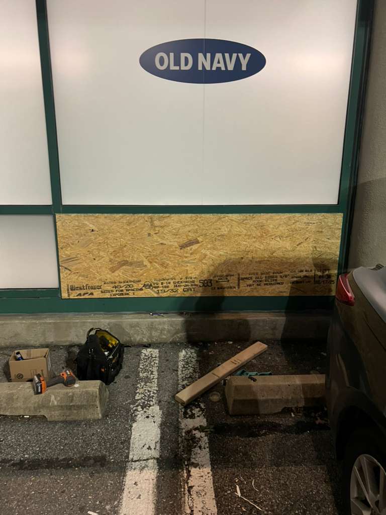Lower storefront glass protected with board-up panel